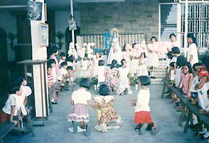 children  performing the Flores de Mayo on their knees