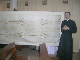Fr. Laisney with his life-size replica of the Holy Shroud