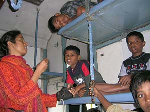 Swarna teaches catechism to boys on the train